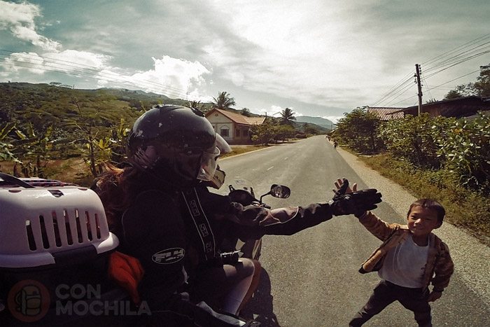 Itinerario de viaje a Laos: Imagen típica de los niños al salir del colegio y vernos con la moto